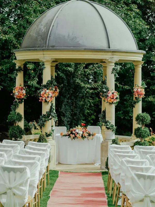 Garden gazebo with flower garlands set up for a wedding ceremony